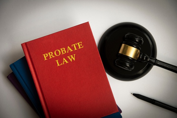 Red book labeled "Probate Law" beside a gavel and pen on a white background.