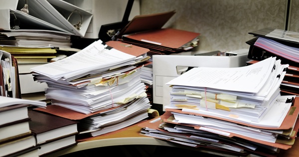 Stacks of complex financial documents and tax records organized on a desk, representing the administrative requirements for filing an Arizona final income tax return after a loved one’s death.